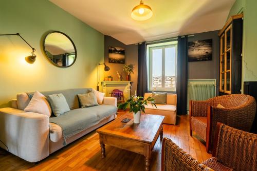 a living room with a couch and a table at Dupain & Dubeurre Appart'hôtel - Parking en supp in Limoges