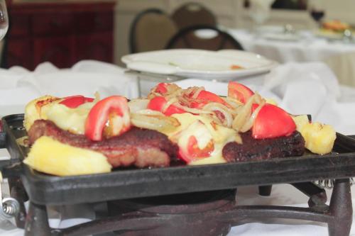a tray of food with meat and tomatoes on it at Hotel del Príncipe in Marabá