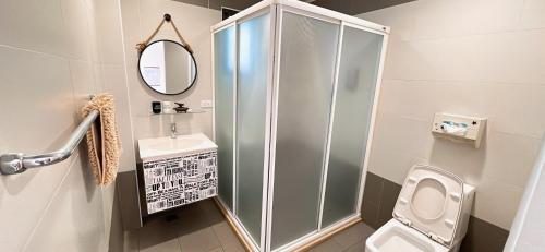 a bathroom with a shower and a toilet and a sink at 木子家民宿 in Magong