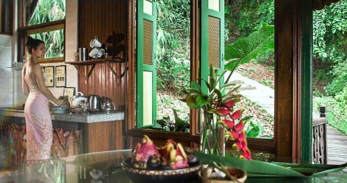 a woman standing in the kitchen of a house at The Dusun in Seremban