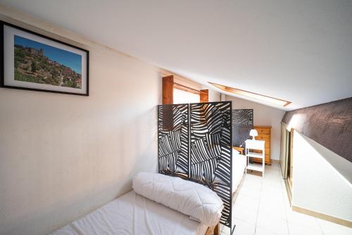 Cette chambre dispose d'un lit blanc et d'une photo murale. dans l'établissement Les Patios de la mer - Maison climatisée St-Cyprien, à Saint-Cyprien