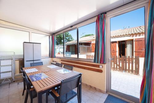 une salle à manger avec une table et une grande fenêtre dans l'établissement Les Patios de la mer - Maison climatisée St-Cyprien, à Saint-Cyprien