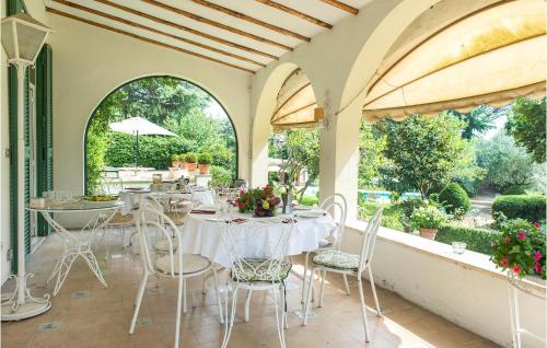 jadalnia z białymi stołami i krzesłami w obiekcie 5 Bedroom Amazing Home In Grottaferrata w mieście Grottaferrata