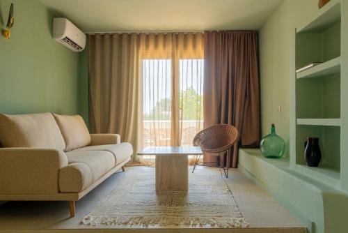 a living room with a couch and a table and a window at MalaQuita Hotel Boutique in Santa Eularia des Riu