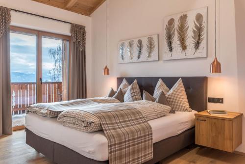 una camera da letto con un letto grande con cuscini di Schartneralm Zirbel Family a Collalbo