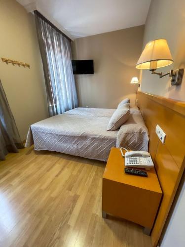 a hotel room with a bed and a desk with a keyboard at Hotel Castilla in Cáceres