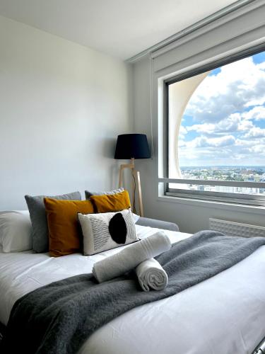 une chambre avec un lit avec une grande fenêtre dans l'établissement L Horizon, Rennes centre, à Rennes
