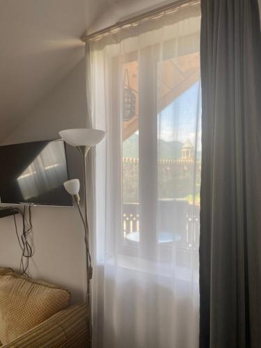 a bedroom with a window with a view of a balcony at Hotel Cité in Mtskheta