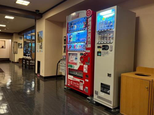 a red vending machine sitting in a room at Shikishimaso in Higashikawa