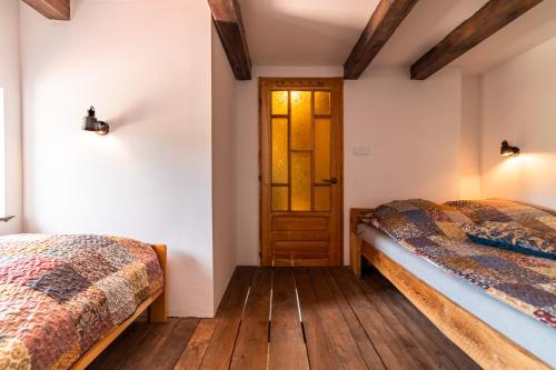 two beds in a room with a door at Chata Mazurska in Orzysz