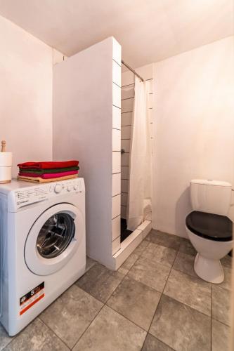 a bathroom with a washing machine and a toilet at Chata Mazurska in Orzysz