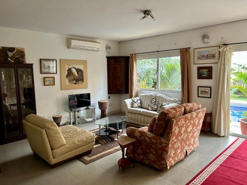 a living room with two couches and a television at Two bedroom villa with private swimming pool and garden in Almadies in Dakar