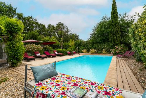 une piscine avec un canapé avec des fleurs à côté dans l'établissement Gîte au coeur du Vaucluse, à Malemort-du-Comtat