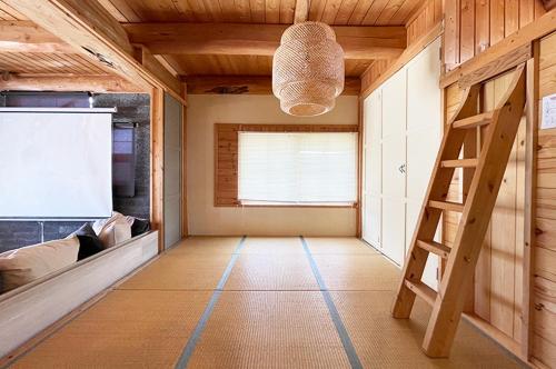 a small room with a ladder and a stairwell at 九十九里 Sunrise Log in Kujukuri