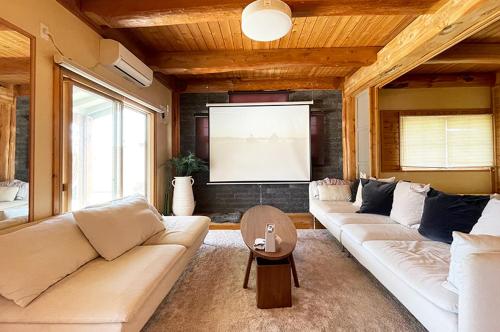 a living room with two couches and a television at 九十九里 Sunrise Log in Kujukuri