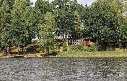 a house on a hill next to a body of water at Amazing Home In Perstorp With Sauna in Perstorp