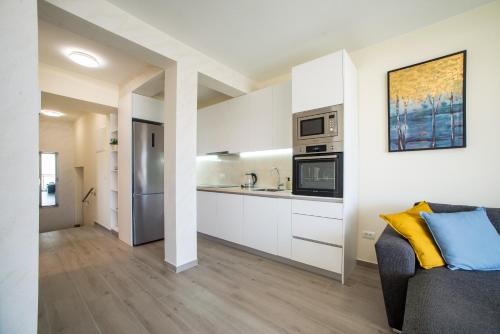 a kitchen with white cabinets and a couch in a room at Villa Linz in Tivat