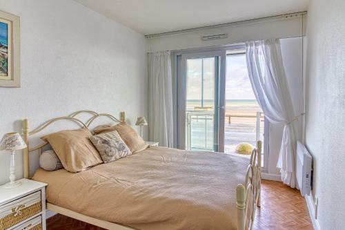 une chambre avec un lit et une grande fenêtre dans l'établissement Les Goélands - vue mer à moins d1 Km de la plage, à Bray-Dunes