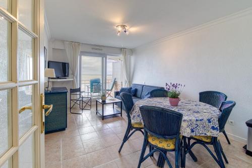 un salon avec une table et un canapé dans l'établissement Les Goélands - vue mer à moins d1 Km de la plage, à Bray-Dunes