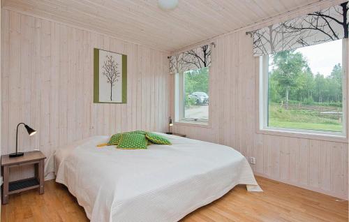 a bedroom with a bed in a room with two windows at Stunning Home In Holmsjö With Kitchen in Holmsjö