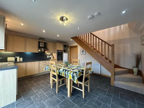 a kitchen with a table with chairs and a staircase at Marina House North and Marina House South in Stromness