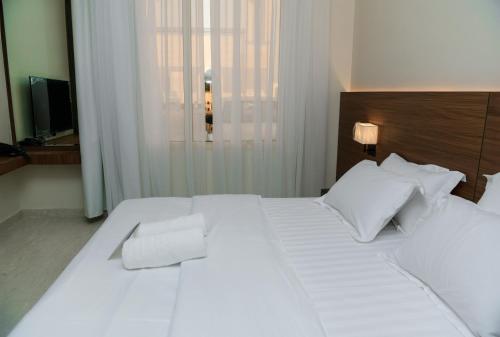 a bedroom with a large white bed with white pillows at ارجان بارك القادسية in Riyadh