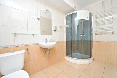 y baño con ducha, aseo y lavamanos. en Pensjonat Stańczyk, en Cracovia