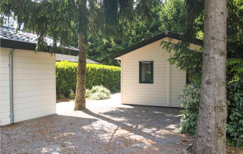 a white garage with a tree next to it at Gorgeous Home In Vorden With Kitchen in Vorden