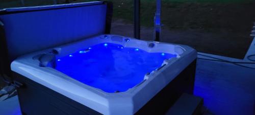 a bath tub with a blue liquid in it at Somos Lux Vendégház in Somoskőújfalu