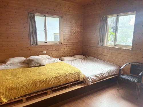 a bedroom with two beds in a room with two windows at B&B American Style cabin 5 minutes from the sea in Hengchun