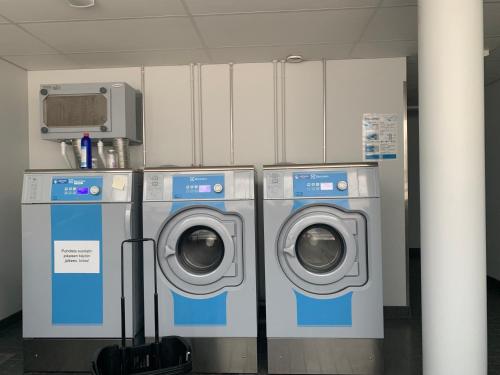 three washing machines and a washer and dryer in a room at 2room Kalasatama Helsinki in Helsinki