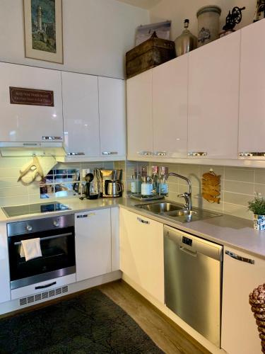 a kitchen with white cabinets and a sink at 2room Kalasatama Helsinki in Helsinki