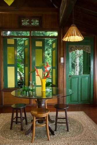 a dining room with a glass table and two stools at The Dusun in Seremban