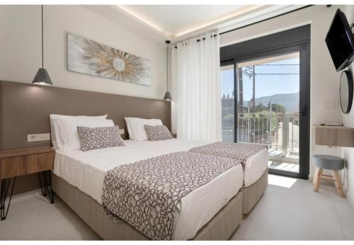 a bedroom with a large bed and a large window at Villa Zografia in Alikanas
