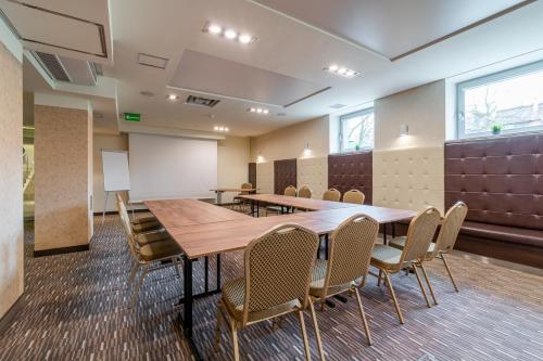a conference room with a wooden table and chairs at Hotel Diament Zabrze - Gliwice in Zabrze