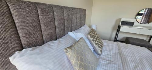 a bed with a headboard with two pillows on it at Arkady House in Olsztynek