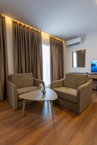a living room with two couches and a coffee table at Acros Resort in Vlorë