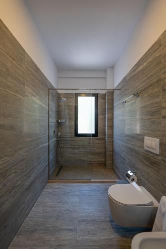 a bathroom with a shower with a toilet and a tub at Acros Resort in Vlorë