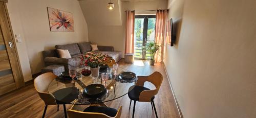 a living room with a glass table and chairs at Arkady House in Olsztynek