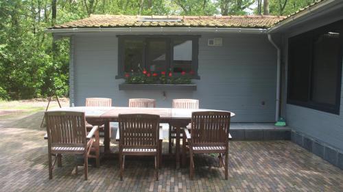 a table and chairs on a patio with a house at Mezenhof in Brasschaat