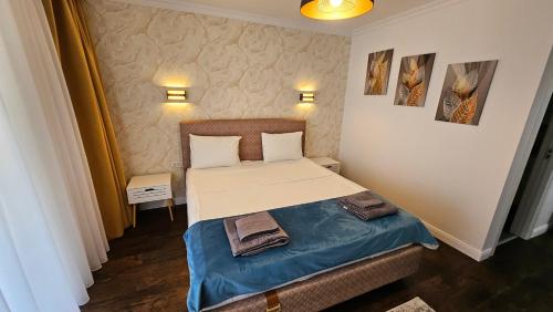 a bedroom with a bed with two towels on it at Luxury 2 bed apartment by Albert in Roşu