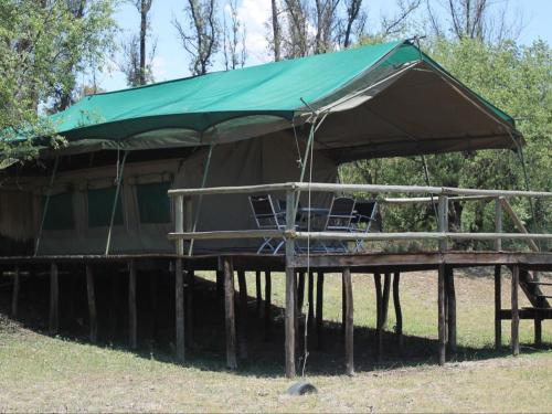 a tent with chairs on a wooden platform at Savannah Game Lodge, Wedding Venue and River Retreat in Parys