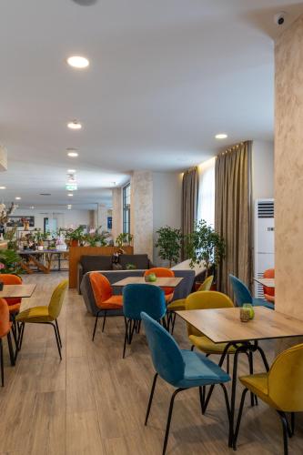 a restaurant with tables and chairs and a couch at Acros Resort in Vlorë