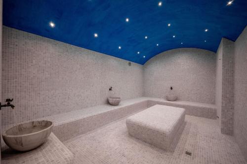 a white bathroom with a tub and a sink at Acros Resort in Vlorë