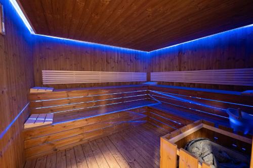 an empty sauna with blue lights on the inside at Acros Resort in Vlorë