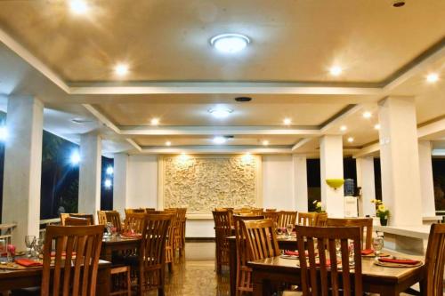 a dining room with wooden tables and chairs at Celosia 1 BR Superior Room AN23 in Mangsit