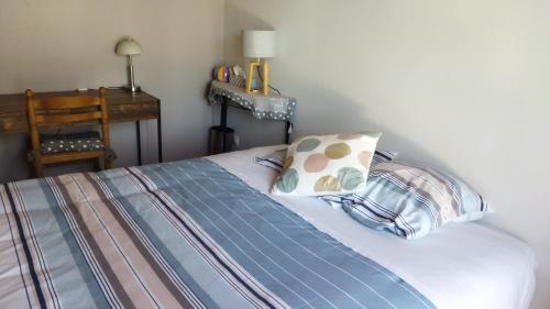 un lit avec deux oreillers dessus dans l'établissement Chambre avec entrée indépendante dans un écrin de verdure, à Dommartin