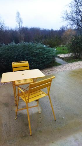une table de pique-nique jaune et une chaise jaune à côté d'un trottoir dans l'établissement Chambre avec entrée indépendante dans un écrin de verdure, à Dommartin