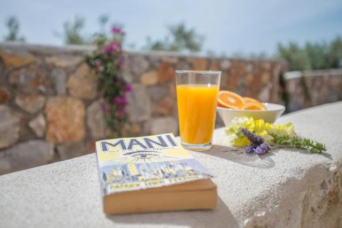 a book and a glass of orange juice on a table at Poliana Estate Villas in Riglia