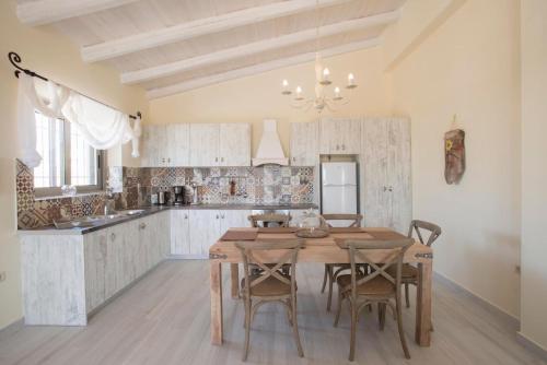 a large kitchen with a wooden table and chairs at Poliana Estate Villas in Riglia